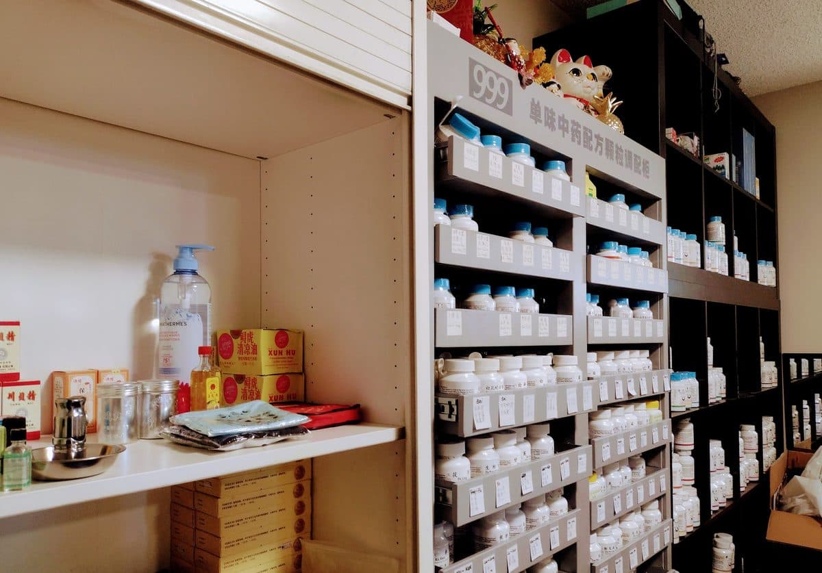 Shelves of herbal granule bottles at the clinic dispensary.